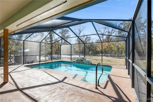 view of pool featuring glass enclosure and a patio area