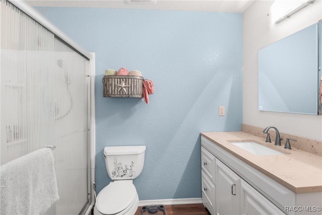 bathroom with vanity, an enclosed shower, and toilet