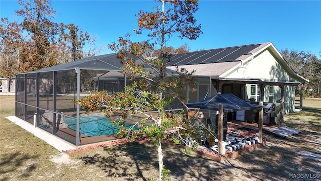 rear view of house featuring solar panels