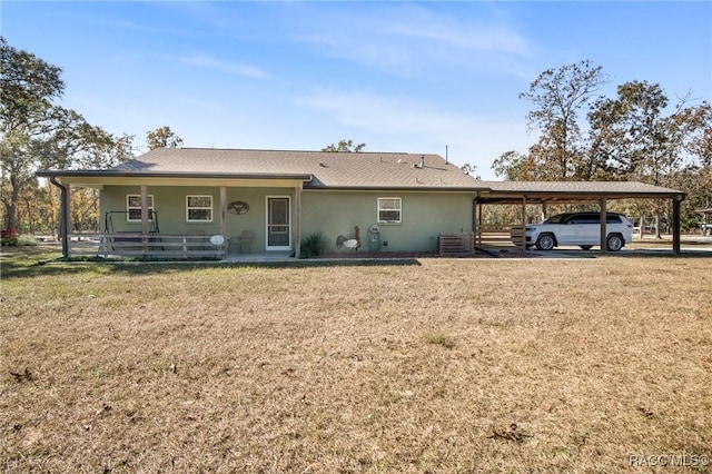 view of front of home with a front yard, central AC, and a carport