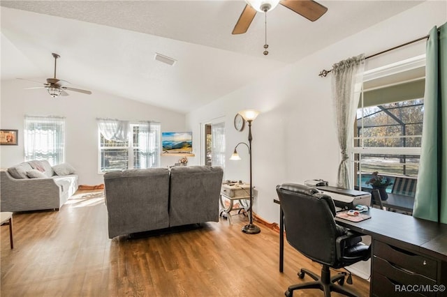 office area featuring a healthy amount of sunlight, vaulted ceiling, and wood-type flooring