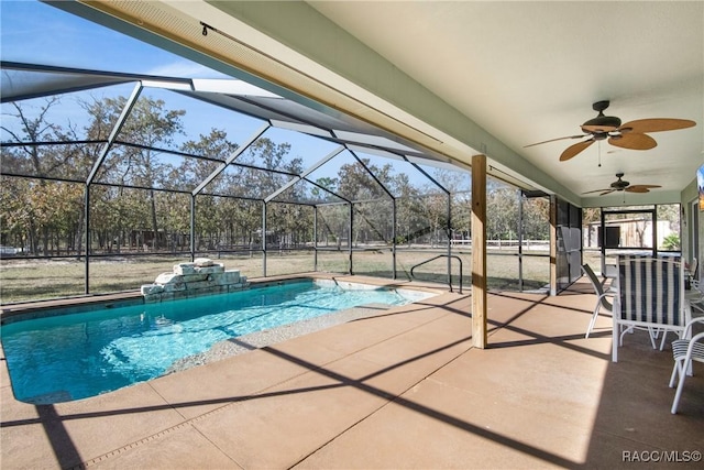 view of pool with a patio, glass enclosure, and ceiling fan