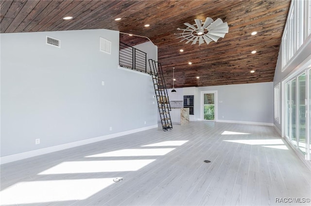 unfurnished living room with light hardwood / wood-style floors, high vaulted ceiling, plenty of natural light, and ceiling fan