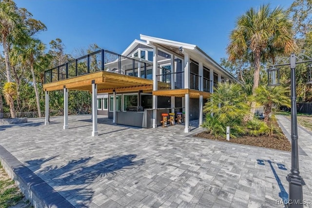 back of house with a sunroom and a patio