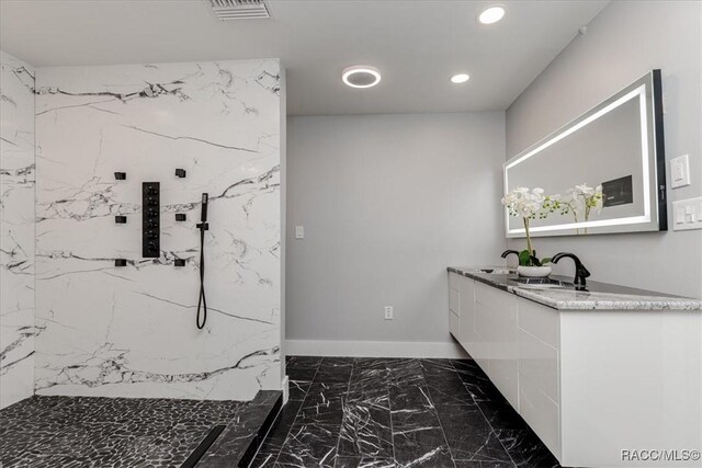 unfurnished bedroom featuring a barn door, a chandelier, ensuite bathroom, and light hardwood / wood-style flooring