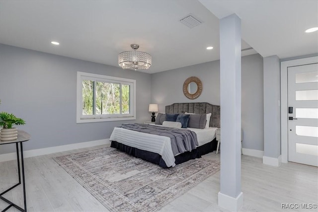 bedroom featuring light hardwood / wood-style floors and a chandelier