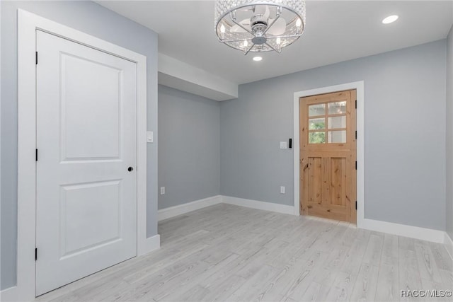 interior space featuring recessed lighting, baseboards, light wood finished floors, and an inviting chandelier
