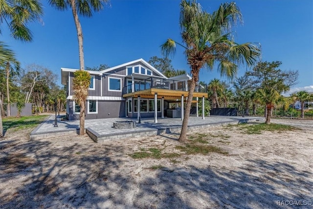 back of house featuring a deck and a patio