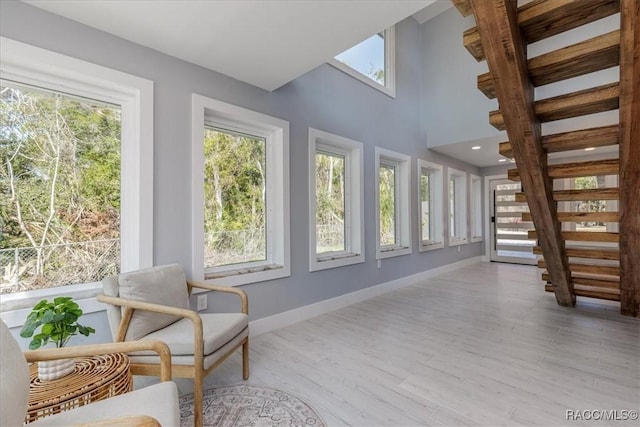 sunroom featuring a wooden deck, plenty of natural light, baseboards, and wood finished floors