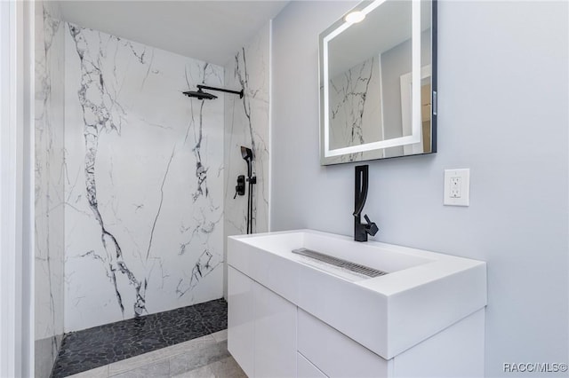 bathroom featuring tiled shower and vanity