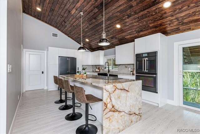 living room with light hardwood / wood-style floors, high vaulted ceiling, and wooden ceiling