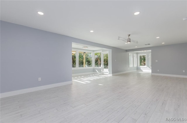 unfurnished room with light wood-type flooring and ceiling fan