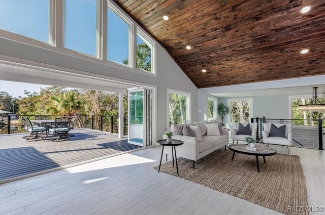 sunroom / solarium featuring ceiling fan, wood ceiling, and lofted ceiling