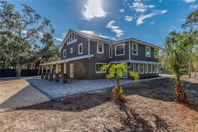 rear view of house featuring metal roof, a patio area, and fence