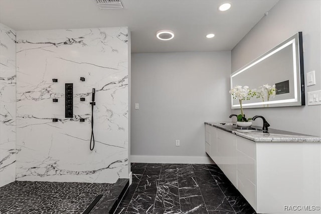 bathroom with vanity and tiled shower