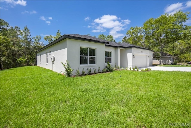 view of home's exterior with a lawn, a garage, stucco siding, and driveway