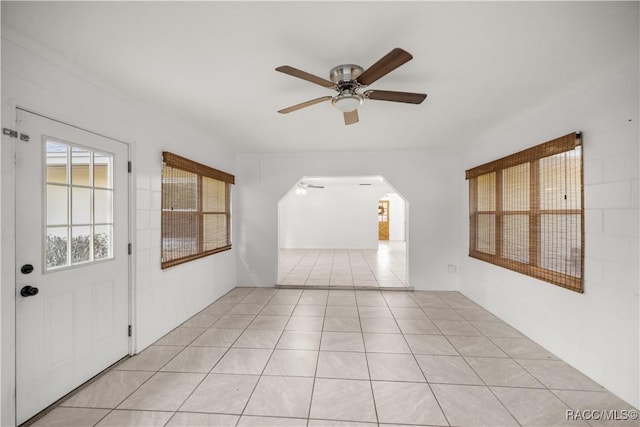 tiled spare room featuring ceiling fan