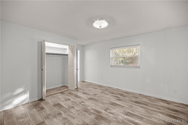 unfurnished bedroom featuring light hardwood / wood-style floors and a closet