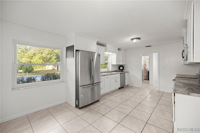 kitchen featuring white cabinets, appliances with stainless steel finishes, and plenty of natural light