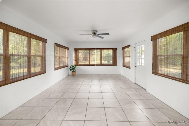 unfurnished sunroom with ceiling fan