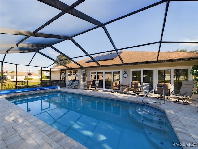 view of swimming pool with glass enclosure and a patio