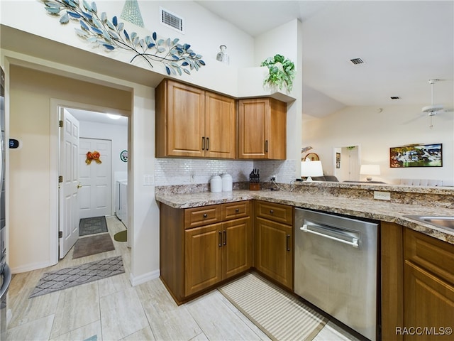 kitchen with dishwasher, backsplash, vaulted ceiling, and light stone counters