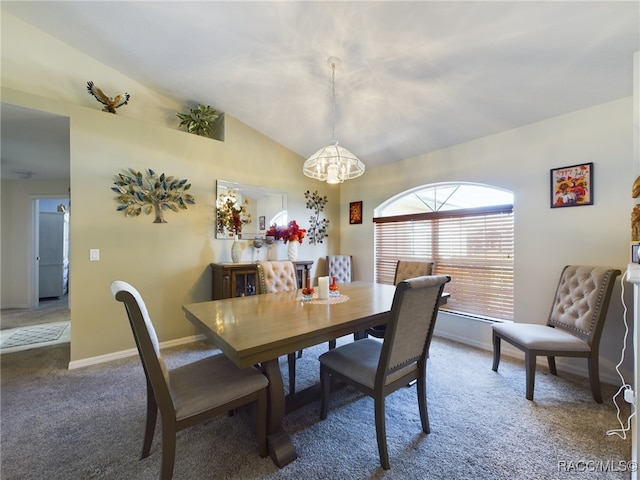 dining area featuring carpet floors, an inviting chandelier, and vaulted ceiling