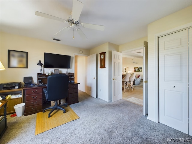 carpeted office space featuring ceiling fan