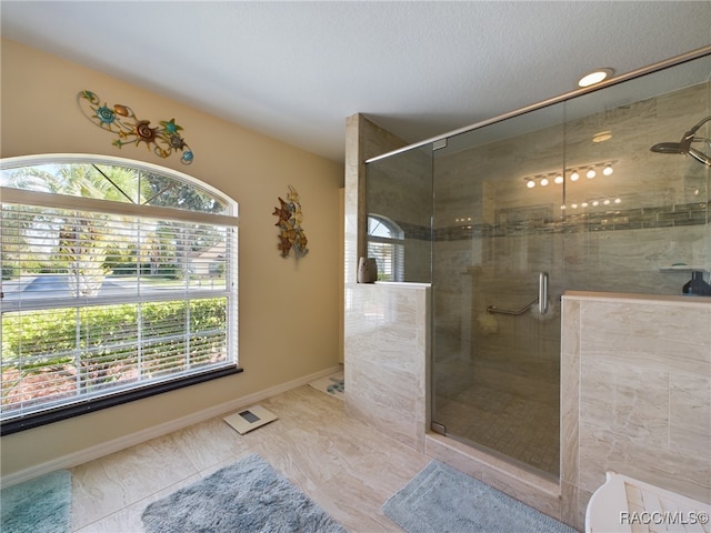 bathroom featuring tile patterned flooring, a shower with shower door, and a textured ceiling