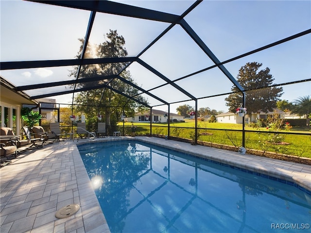 view of swimming pool featuring a patio and glass enclosure