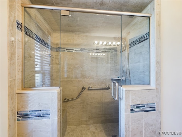 bathroom with a shower with door