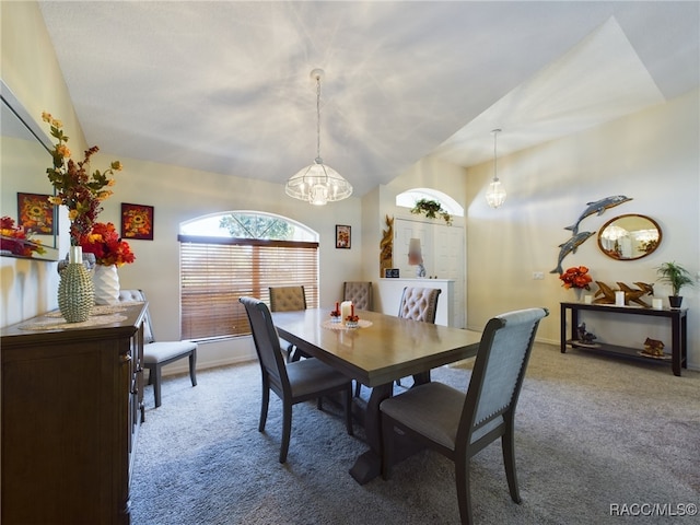 dining area featuring lofted ceiling, carpet floors, and an inviting chandelier