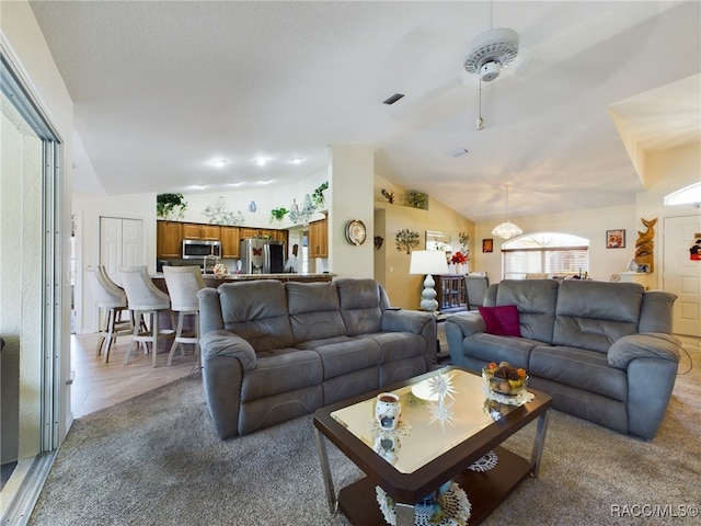 carpeted living room featuring vaulted ceiling