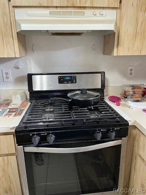 interior details featuring light brown cabinetry and gas stove