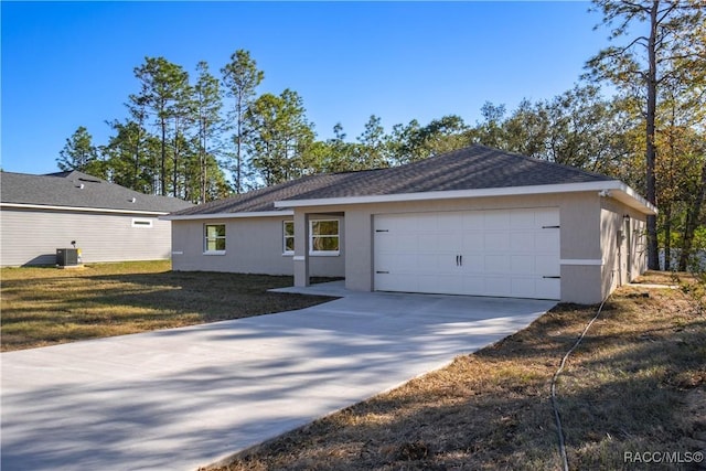 ranch-style house with a garage, central air condition unit, and a front yard