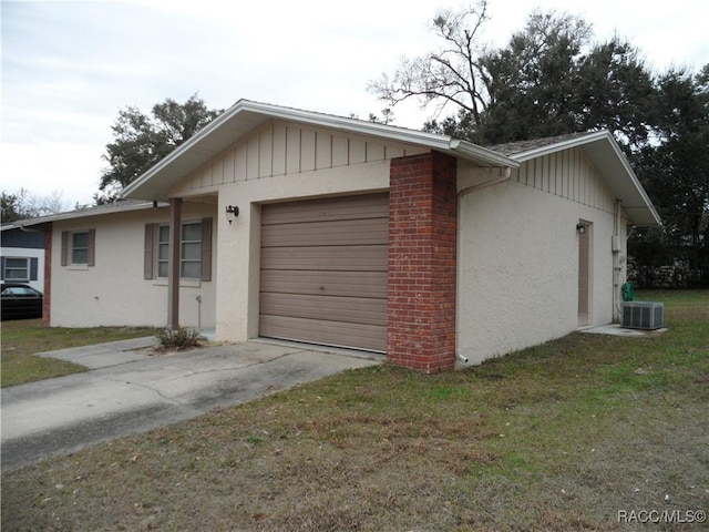 view of home's exterior with a lawn, a garage, and central AC unit