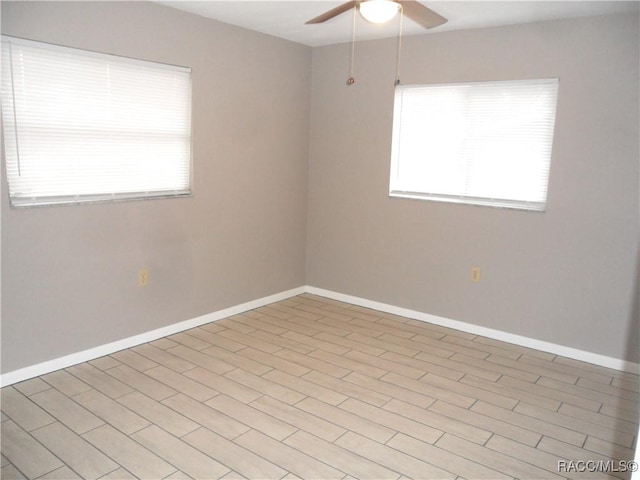 spare room featuring ceiling fan, light hardwood / wood-style floors, and plenty of natural light