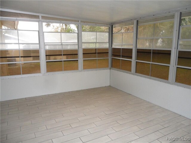 unfurnished sunroom featuring lofted ceiling