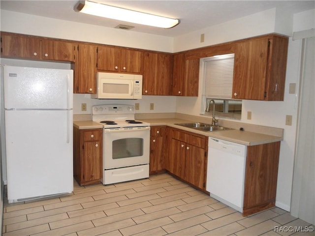 kitchen with sink, white appliances, and light hardwood / wood-style floors