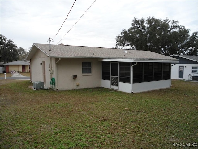 back of house featuring a yard, central air condition unit, and a sunroom