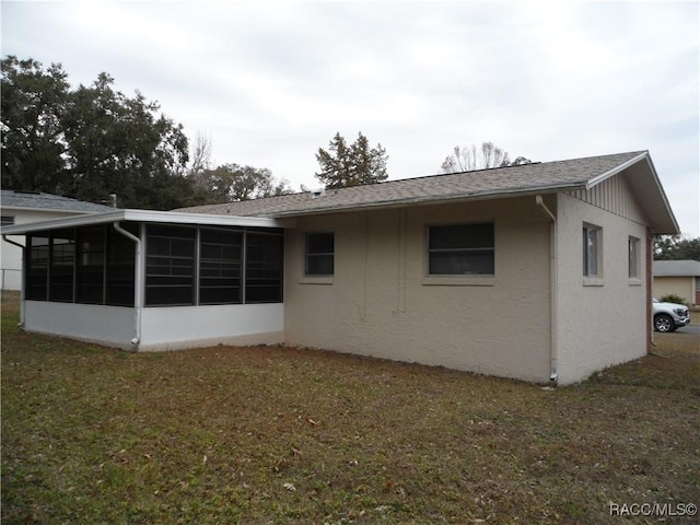 back of property with a yard and a sunroom