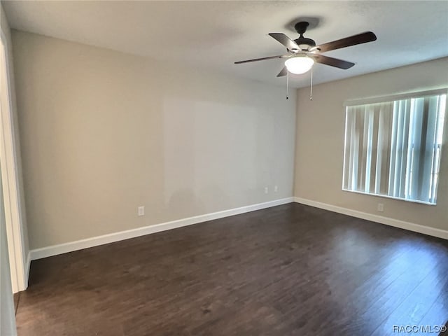 spare room featuring ceiling fan and dark wood-type flooring