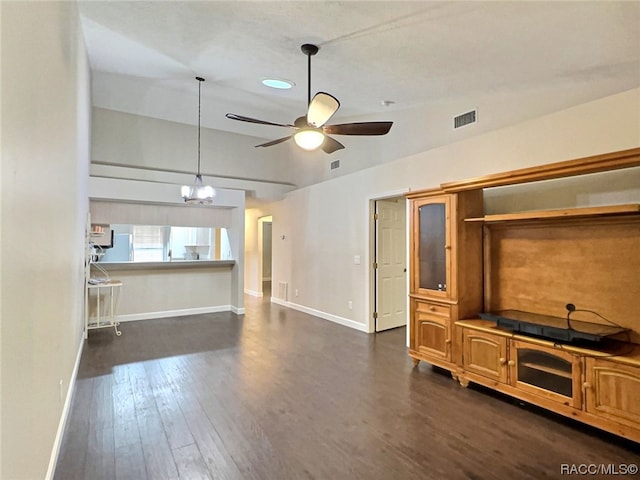 unfurnished living room with ceiling fan with notable chandelier and dark hardwood / wood-style floors