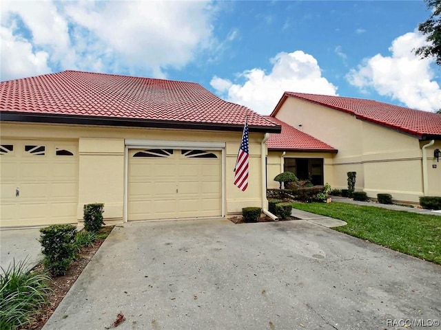 2058 Forest Dr, Inverness, FL 34453 - mediterranean / spanish-style home featuring concrete driveway, a tile roof, stucco siding, and a garage
