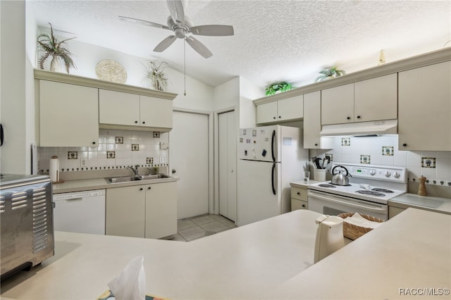 761 W Sunbird Path, Hernando, FL 34442 - kitchen featuring white appliances, under cabinet range hood, cream cabinetry, decorative backsplash, and vaulted ceiling