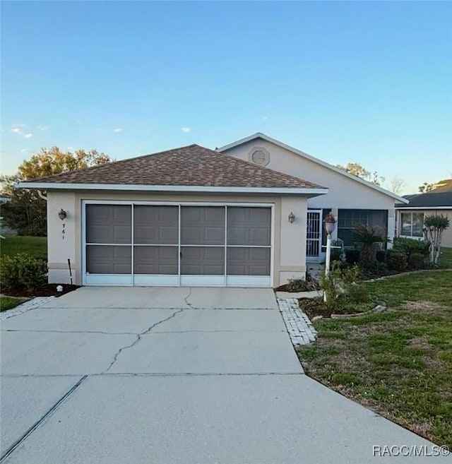 single story home featuring stucco siding, concrete driveway, a shingled roof, and a front yard