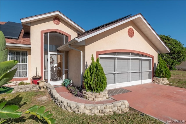 view of front of property with a garage and solar panels