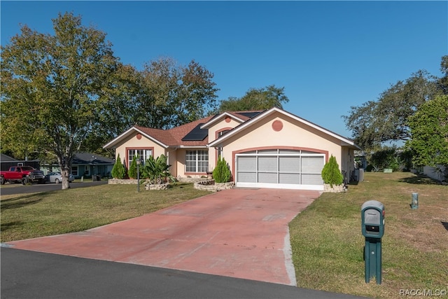 ranch-style home featuring solar panels, a garage, and a front lawn