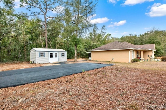 view of property exterior featuring an outdoor structure and stucco siding