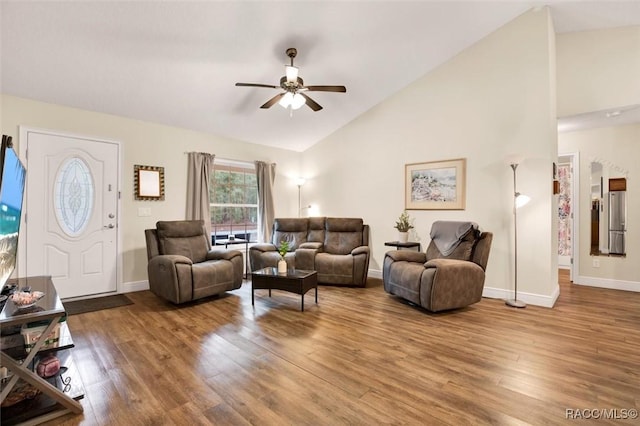 living area with high vaulted ceiling, wood finished floors, and baseboards